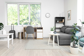 Interior of living room with modern grey sofa, coffee table and workspace
