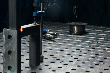 на металлическом столе детали соединены электросваркой шов остывает