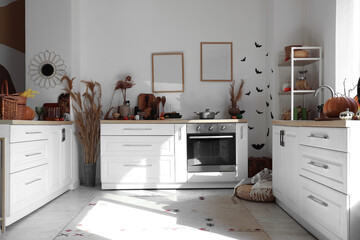 Interior of light kitchen decorated for Halloween with counters and shelf unit