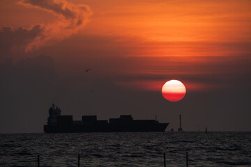 Cargo ship sailing on the sea at sunset