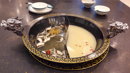A unique hotpot decorated with the dragon's head statue containing traditional Chinese herbal concoctions