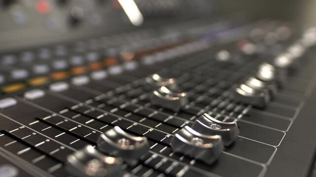 Faders of professional mixing console for sound control. Certain slider position on device affects channel volume in overall balance