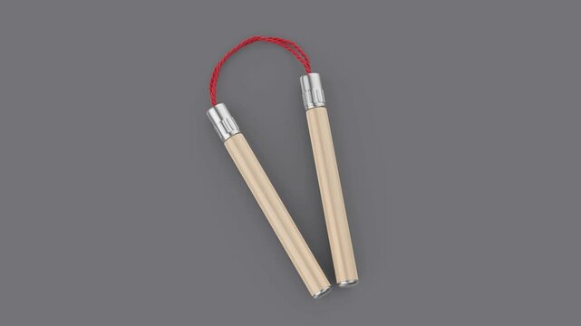 Wooden nunchaku with red cord on grey background
