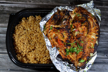 Sinjari Tilapia Fish, the fish is opened and grilled with oil and lemon or cooked and baked in the oven with vegetables parsley, tomato, onion and small shrimps, served with cooked red fish rice