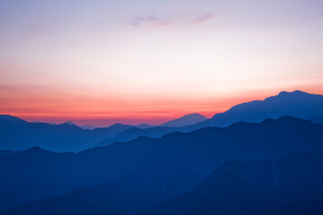 Sunrise view of magnificent layered mountains and colorful clouds background in Taiwan.