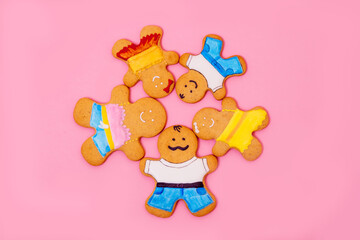 Top view of a family of gingerbread men on a pink background. Ginger cookies. Food concept. Family Day.