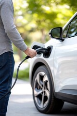 closeup of a man charging his white electric car on road