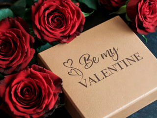 Photo of a bouquet of red roses with a gift box and a Valentine's Day greeting card