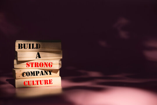 Company culture symbol. Wooden blocks with words Build a strong company culture. Beautiful pink background. Business and Company culture concept. Copy space.