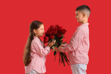 Cute little kids with bouquet of roses on red background. Valentine's Day celebration © Pixel-Shot