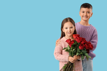 Cute little kids with bouquet of roses on blue background. Valentine's Day celebration