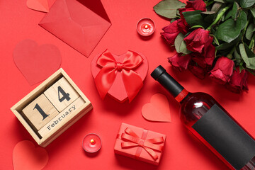 Composition with calendar, gift boxes, bottle of wine and rose flowers on red background....