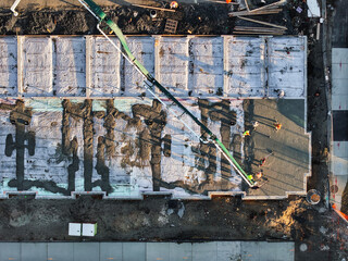 Top down view of concrete being poured on a foundation