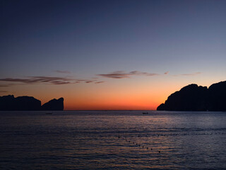 A stunning sunset is casting vibrant hues of color over a tranquil ocean