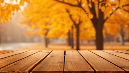 Empty wooden table top set in an autumn park, with a blurred backdrop of vibrant trees and fallen leaves.