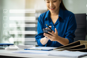 Business performance checklist concept, business woman using smartphone and laptop doing online...