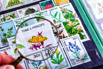Philately.Collection of stamps and magnifying glass.Spring themed stamp collection.A page of storage book album for storing old postage stamps.