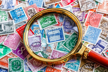 Philately.Postage stamps.Collection of stamps and magnifying glass.A collection of world stamps in a pile.Postage stamps from different countries and times