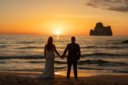sposi che guardano tramonto sul mare