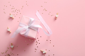 Beautiful gift box, paper pins and sequins on pink background. Valentine's Day celebration