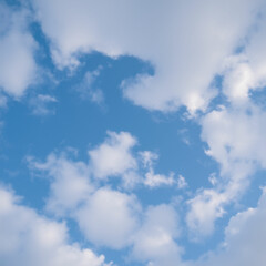 Obraz premium Low angle view of a clear blue sky and fluffy clouds in the background.