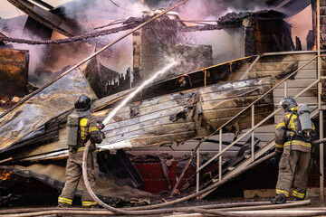 Fire incident in building. Action photo fireman team extinguishes burn with hose water