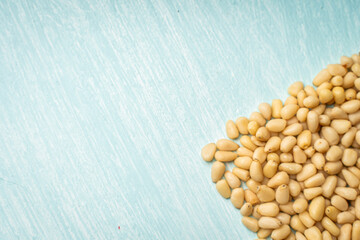 Pine nuts on blue, wooden background. Space for text. Copyspace.