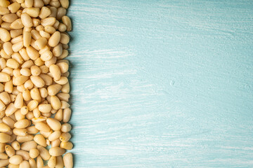 Pine nuts on blue, wooden background. Space for text. Copyspace.