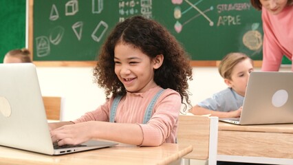 Attractive girl coding prompt while looking at camera at STEM class while happy teacher checking...