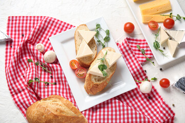 Composition with bread, tasty cheese, vegetables and micro green on light background