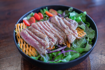 Salad with sliced medium rare meat served on plate