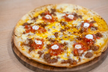 Cheese Nacho with meat on top, served with tomato salsa dip sauce