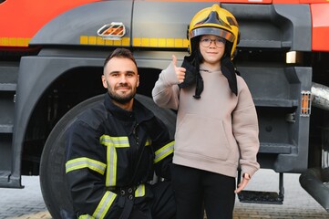 Fototapeta premium Firefighter holding child boy to save him in fire and smoke,Firemen rescue the boys from fire