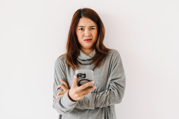 Fototapeta premium Asian Thai woman wear sweater, holding and using mobile phone with doubt face, unbelievable, communication problem.