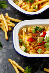 Loaded vegetarian fries with avocado, roasted peppers, jalapeno peppers and cheddar cheese