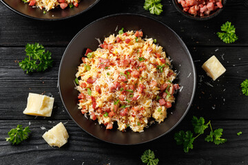 Carbonara fried rice with pancetta, pecorino romano cheese, eggs in a black bowl