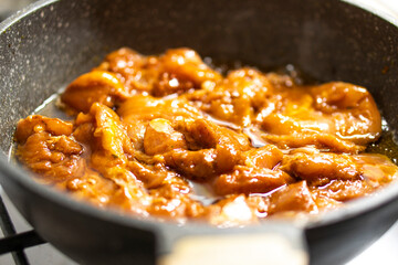 Chicken pieces are fried in a frying pan. Meat cooking. Food concept