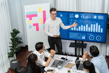Presentation in office or meeting room with analyst team utilizing BI Fintech to analyze financial data. Businesspeople analyzing BI dashboard power display on TV screen for strategic planning.Prudent