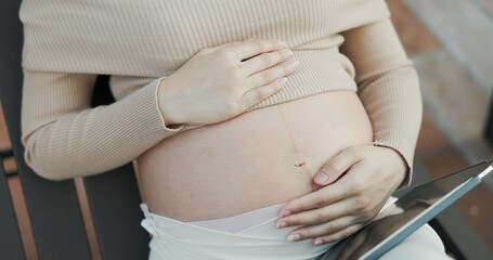 Closeup hand Pregnant woman touch belly with her hands to caress baby to be born. pregnancy mom take care, mental health, happy. single mother caresses belly make unborn baby feel good. Health care
