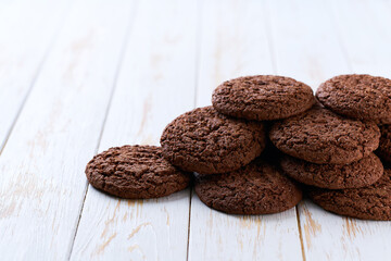 Heap of chocolate cookies  on a white table, with copy space for text.
