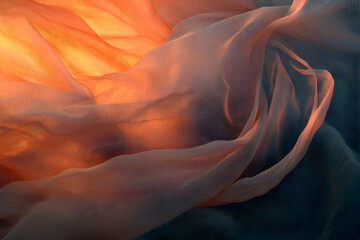 Obraz premium Draped fabric illuminated by warm light, creating soft shadows and textures.