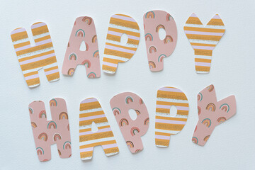 paper sign composed of machine-cut paper letters arranged to say: happy, happy