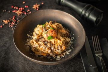 A gourmet dish of creamy mushroom pasta garnished with chestnuts and fresh greens