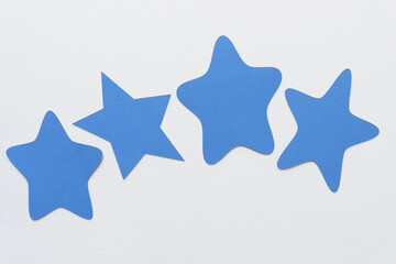 unique star shapes machine-cut from blank blue paper and arranged on blank paper