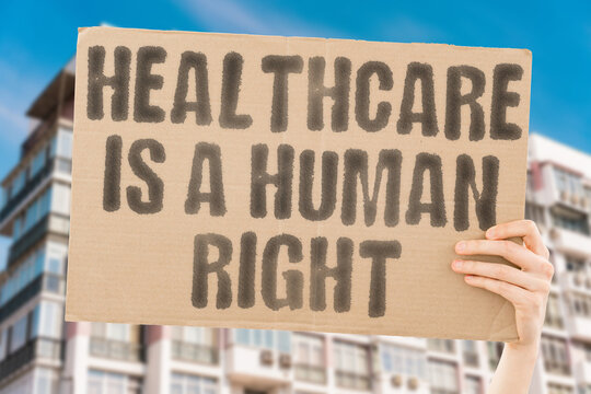 A cardboard banner displaying 'Healthcare is a human right' advocates for equality and healthcare access for all. Rights. Equality. Access. Homeless. Poor. Justice. Health