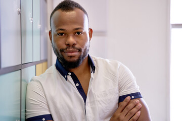 Attractive confident African American male with cheerful expression and beard looking at camera in...