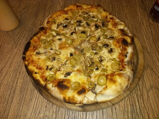 Pizza with yellow cheese and toppings on vegetables on the pizza
