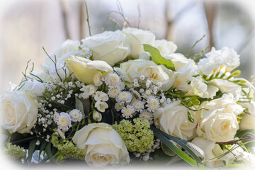 Funeral flowers at the cemetery. Memorial flowers, the main color is white. A beautiful arrangement of white roses and other white flowers.