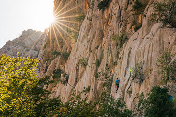 landscape of the mountains, climber in the wall, beautiful sun lens flare, multi pitch, climbing, croatia, paklenica, national park, alpinism