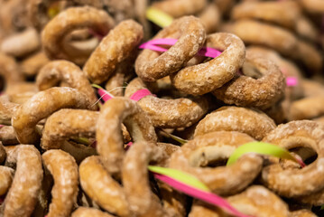 A large quantity of pretzels hanging on a string. Close-up shot of a pretzel. A lot of bagels..